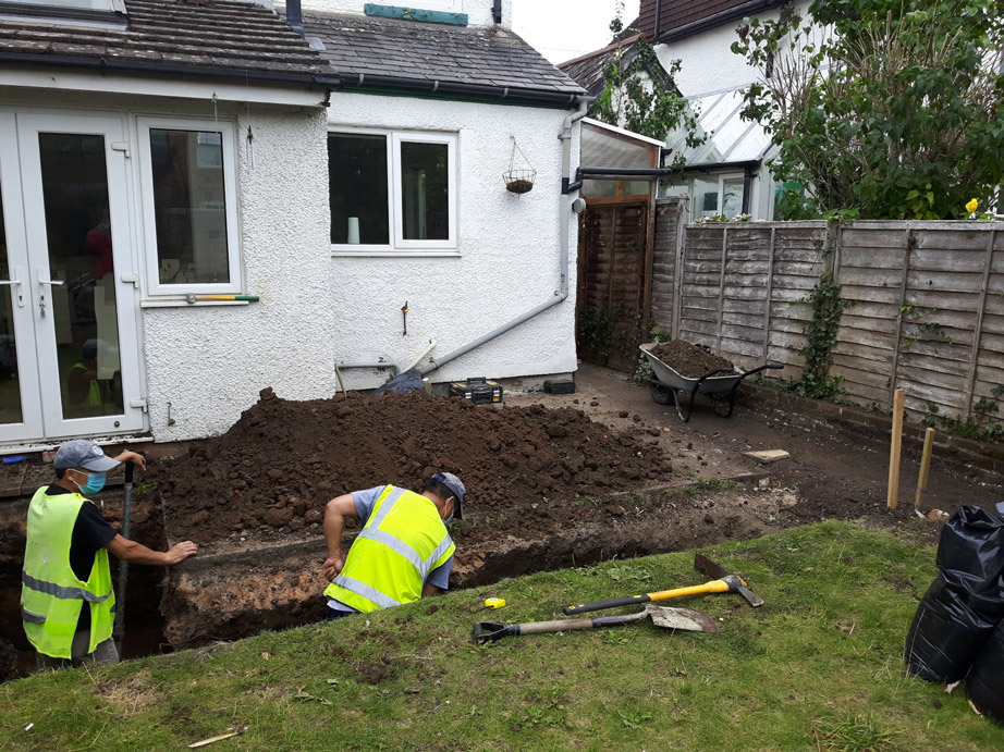 New rear extension in West Oxford,  foundation trenches being dug by masked ground workers